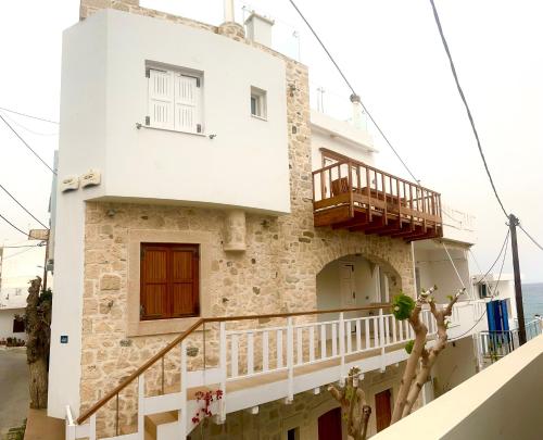 a white house with a balcony and the ocean at Blue Horizon Apartment in Myrtos