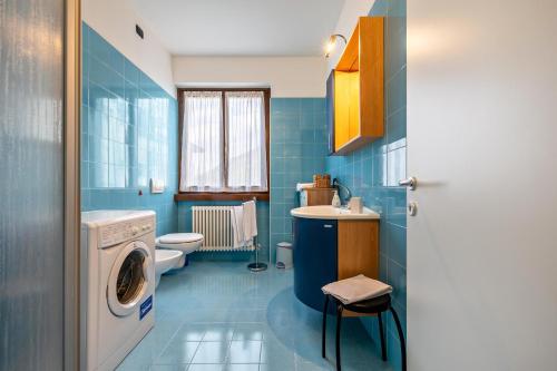 a blue bathroom with a washing machine and a sink at Appartamenti Villa Adriana Torbole in Nago-Torbole