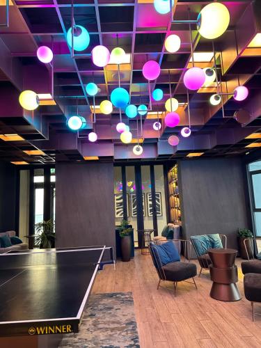 a ping pong table in a room with a ceiling with lights at EDGE Cozy Vacation Condo infinite SKY Pool in Pattaya Central