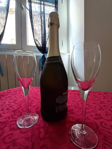 a bottle of wine and two glasses on a table at Tola Dream Apartment in Sassari