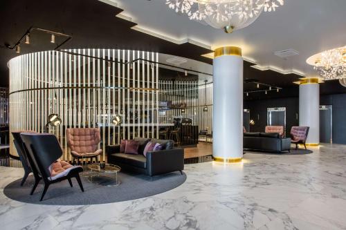 a lobby with couches and chairs and a chandelier at Radisson Collection Hotel, Tallinn in Tallinn