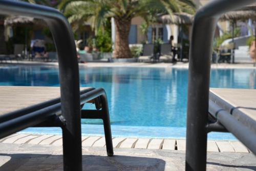 a chair sitting next to a swimming pool at Zephyros Hotel in Kamari