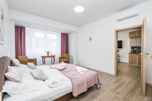 1 dormitorio con 1 cama grande con manta rosa en Perla Hradce 202, en Hradec Králové