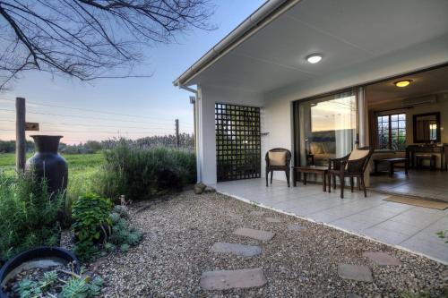 a home with a patio with a table and chairs at De Old Drift Guest Farm in Addo
