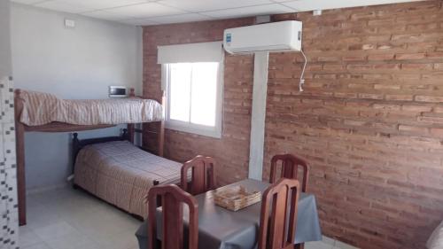ein Schlafzimmer mit einem Etagenbett, einem Tisch und Stühlen in der Unterkunft LA Tranquera DPTOS 2 in San Luis