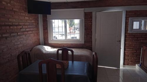 ein Wohnzimmer mit einem Sofa, einem Tisch und einem Fenster in der Unterkunft LA Tranquera DPTOS 2 in San Luis