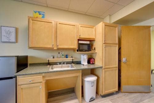 a kitchen with wooden cabinets and a sink and a refrigerator at 20 Mi to Dtwn Pittsburgh Pet-Friendly Apartment in New Kensington
