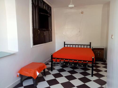 a bedroom with a red bed and a checkered floor at Hamed Guest House in Aswan