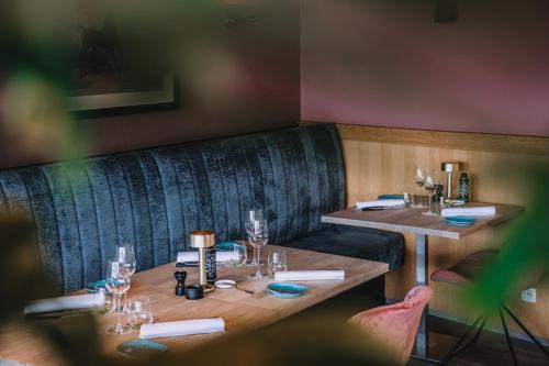 a dining room with two tables and a bench at Hotel Les Eleveurs in Halle