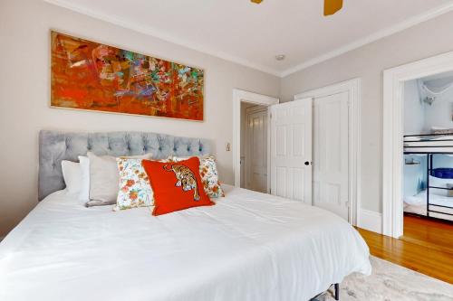 1 dormitorio con cama blanca y almohadas rojas en Witchy Modern, en Salem