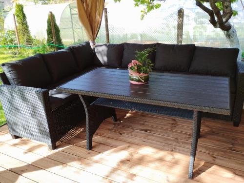 a black couch and a table on a patio at VilkuNams in Dubeņi