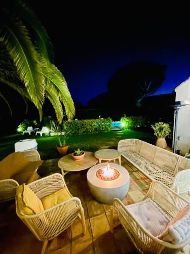a patio with a fire pit with chairs and a table at Villa provençale Golfe St Tropez climatisée piscine chauffée, Spa, billard, Wifi haut débit pro in Gassin