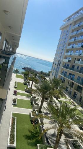 una vista aérea de un complejo con palmeras y el océano en Marjan Island Beautiful Apartment Sea View Beach Luxury Rooms Ras Al Khaimah UAE, en Ras al Khaimah