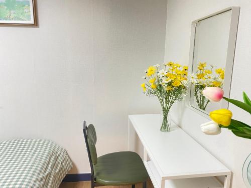 una stanza con tavolo e vaso di fiori di Magic room HONGDAE GUESTHOUSE a Seul