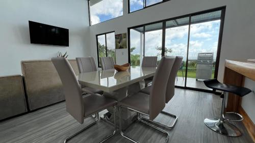 a dining room with a glass table and chairs at Canavida Villas & Resort in Uvita