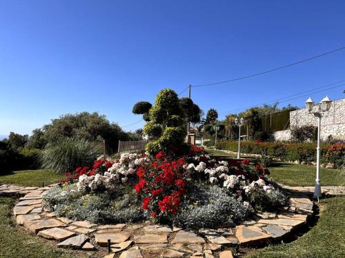 a garden with red and white flowers in a park at Villa Puerto de la Luz in Mijas