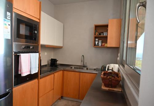 a small kitchen with a sink and a microwave at Athina's Stone House in Kardamyli in Kardamili