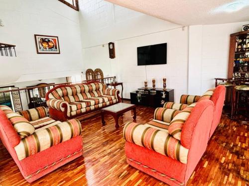un soggiorno con divani e TV a schermo piatto di Gaby’s Home. a Quito