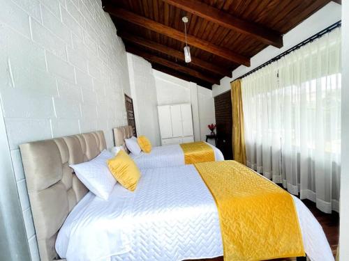 una camera con 2 letti con cuscini gialli di Gaby’s Home. a Quito
