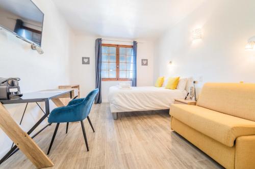 een kamer met een bed, een tafel en een bank bij Relais du Bas Limousin in Sadroc