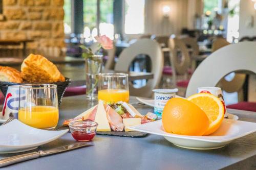 een tafel met een bord sinaasappels en glazen sinaasappelsap bij Relais du Bas Limousin in Sadroc