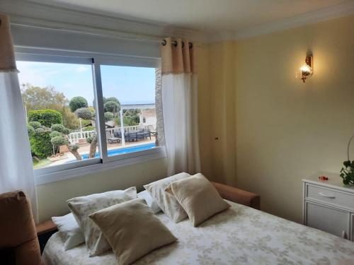 a bedroom with a bed with a large window at Villa Puerto de la Luz in Mijas