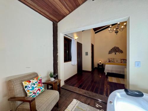 a living room with a couch and a bed at Pousada Chalés Jardim das Bromélias - Visconde de Mauá in Visconde De Maua