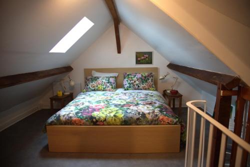 a bedroom with a bed in a attic at Clair logis in Giverny
