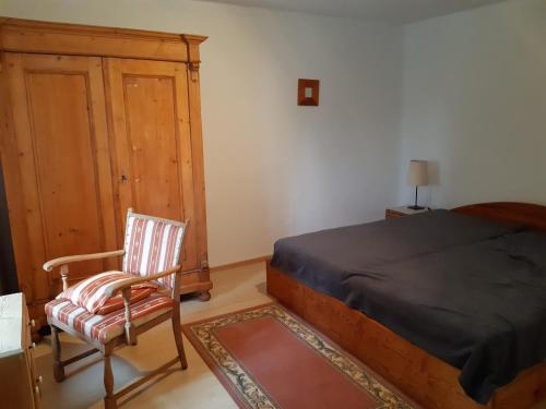 a bedroom with a bed and a chair and a cabinet at Mjesto mira Ort des Friedens in Bribir