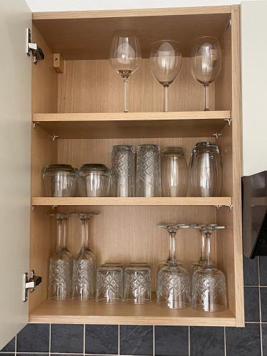 a cabinet filled with glass wine glasses on display at Belle-Vue Apartments in Hunstanton