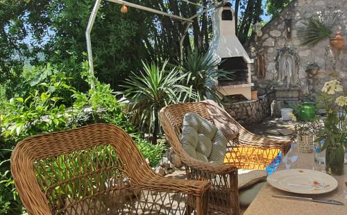 three wicker chairs and a table in a garden at Mjesto mira Ort des Friedens in Bribir
