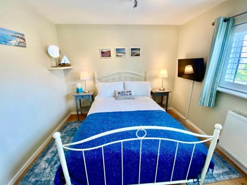 a bedroom with a bed with a blue comforter at Bosham Bed & Breakfast in Bosham