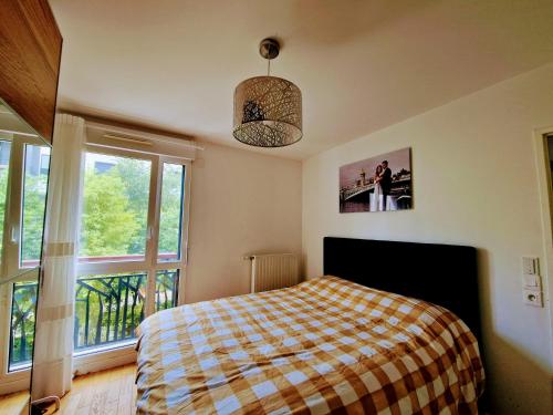 sypialnia z łóżkiem i dużym oknem w obiekcie Appartement confort Paris JO 2024 w mieście Colombes