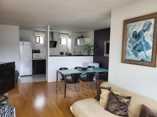 un salon avec une table et un canapé dans l'établissement Aibnb Paris Stade de France notre-Dame Tour Eiffel, à Saint-Denis