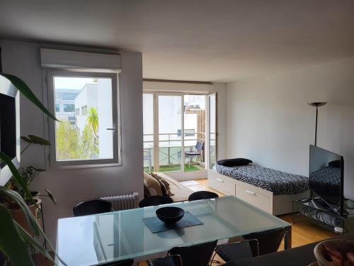 un salon avec une table et une fenêtre dans l'établissement Aibnb Paris Stade de France notre-Dame Tour Eiffel, à Saint-Denis