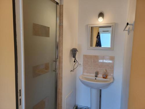 une salle de bain avec un lavabo et un miroir dans l'établissement Aibnb Paris Stade de France notre-Dame Tour Eiffel, à Saint-Denis