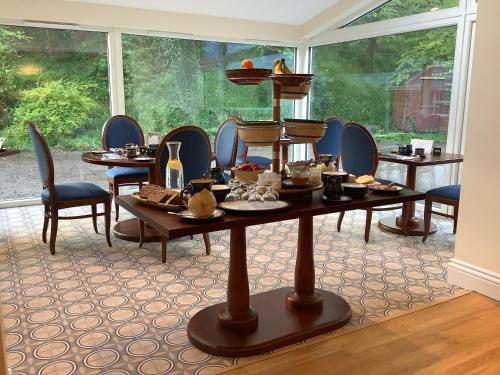 ein Zimmer mit Tischen und Stühlen und einem großen Fenster in der Unterkunft Gleann Fia Country House in Killarney