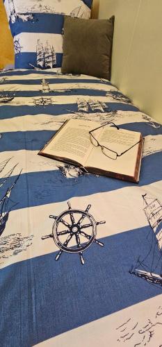 a bed with a book with a ship on it at 250 mobile home Selce in Selce