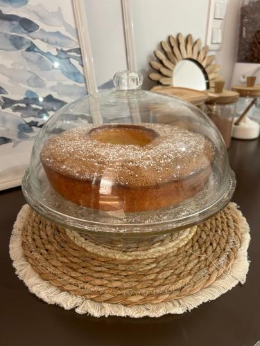 a cake in a glass dome on a table at Hôtel de la jetée in Centuri