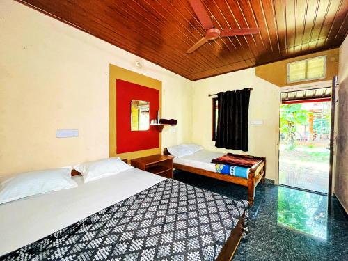 a bedroom with two beds and a ceiling fan at Isiri river side stay in Kalasa