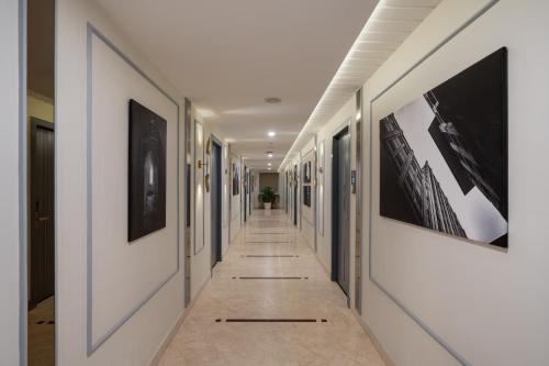 a hallway with pictures on the walls and a long hallway with a hallwayngthngth at Pelican Inn in Bangalore