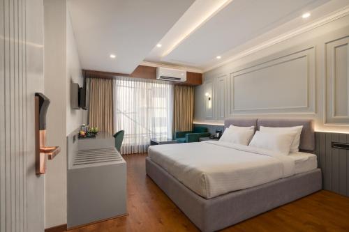 um quarto de hotel com uma cama e uma secretária em Pelican Inn em Bangalore