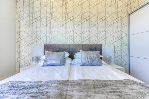 um quarto com uma grande cama branca com almofadas azuis em Villa A&D em Slatine
