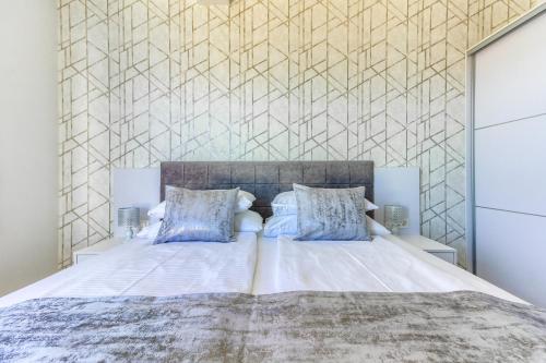 Un dormitorio con una gran cama blanca con almohadas azules. en Villa A&D, en Slatine