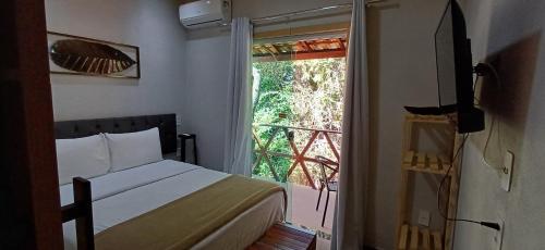 a bedroom with a bed and a door to a balcony at Pepalantus Flats in Santana do Riacho