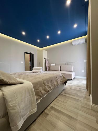地拉那的住宿－Spiranca Apartments & Rooms，一间卧室设有两张床和蓝色的天花板