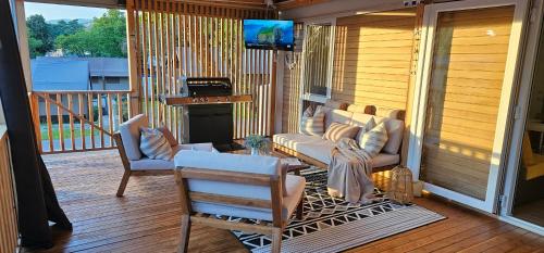 a porch with a couch and two chairs and a television at 250 mobile home Selce in Selce