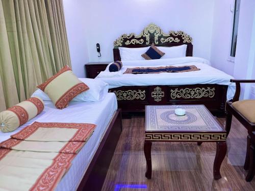 a hotel room with two beds and a table at Areesh Hotel & Restaurant in Lower Topa