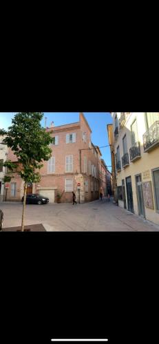 une rue vide avec un bâtiment et un arbre dans l'établissement Studio de charme - coeur de ville, à Perpignan