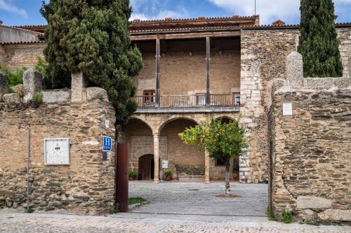una entrada a un castillo con una pared de piedra en Hospedería Puente de Alconétar, en Garrovillas